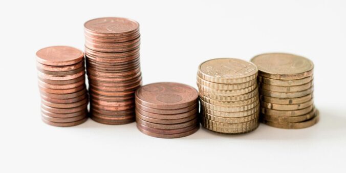 stacked round gold-colored coins on white surface